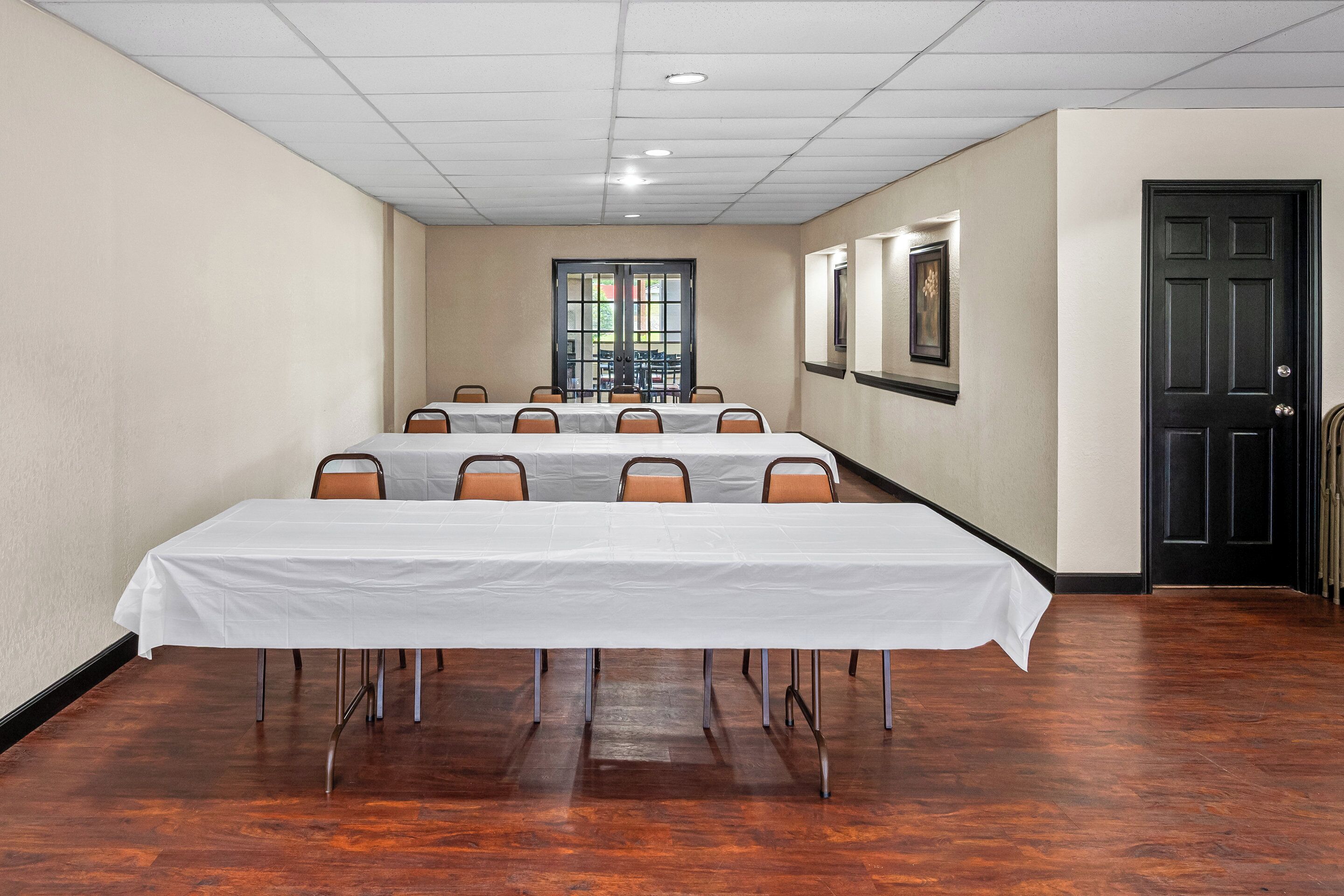 A conference room with a long table, chairs, and a door.