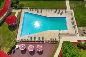 Una piscina al aire libre de temporada, sombrillas