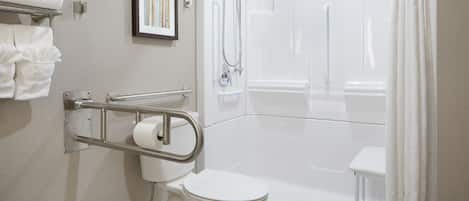 A modern bathroom with a toilet, shower, and a handrail for accessibility.