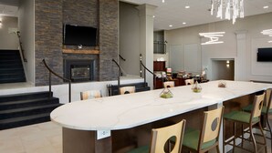 Una cocina moderna con una isla grande, electrodomésticos integrados y una pared de acento de piedra.