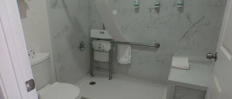A bathroom with a toilet, a shower with a glass door, a sink, and a towel rack.