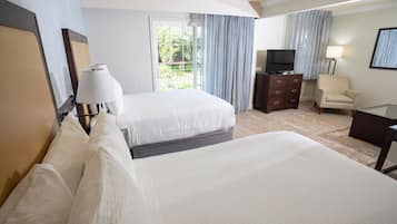 Una habitación de hotel con dos camas, televisión, una silla y escritorio.