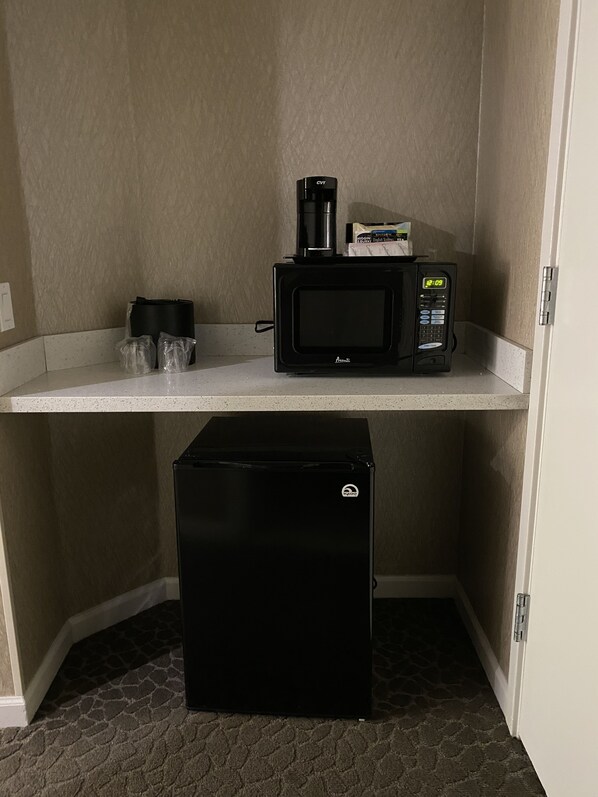 A kitchenette with a microwave, coffee maker, and refrigerator. - Creekside Inn (Palo Alto)