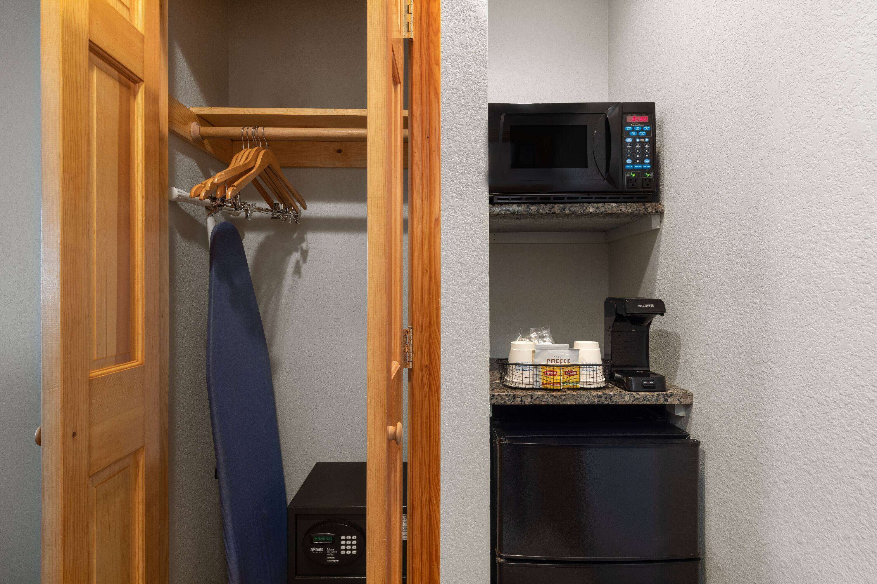 A compact kitchen with a microwave, coffee maker, and a small refrigerator.