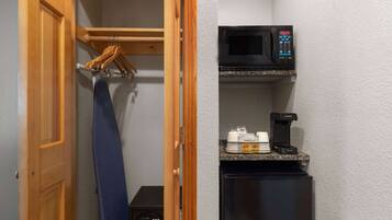 A compact kitchen with a microwave, coffee maker, and a small refrigerator.