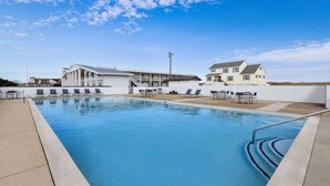 A swimming pool with lounge chairs and a building with a staircase. - Days Inn by Wyndham Kill Devil Hills Oceanfront - Wilbur (Kill Devil Hills)