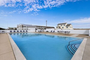 Una piscina al aire libre de temporada, sillones reclinables de piscina