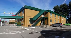 Welcome to our hotel, featuring a distinctive entrance with stairs leading up to the main door and convenient parking available on site.