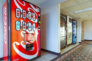 A hallway with vending machines, including Coca-Cola and Pepsi, and a patterned carpet. - Quality Inn and Conference Center I-80 Grand Island (Grand Island)