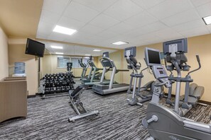 A fitness center with treadmills, elliptical machines, and free weights.