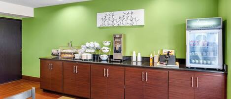 Una kitchenette con cafetera, tostadora y refrigerador.