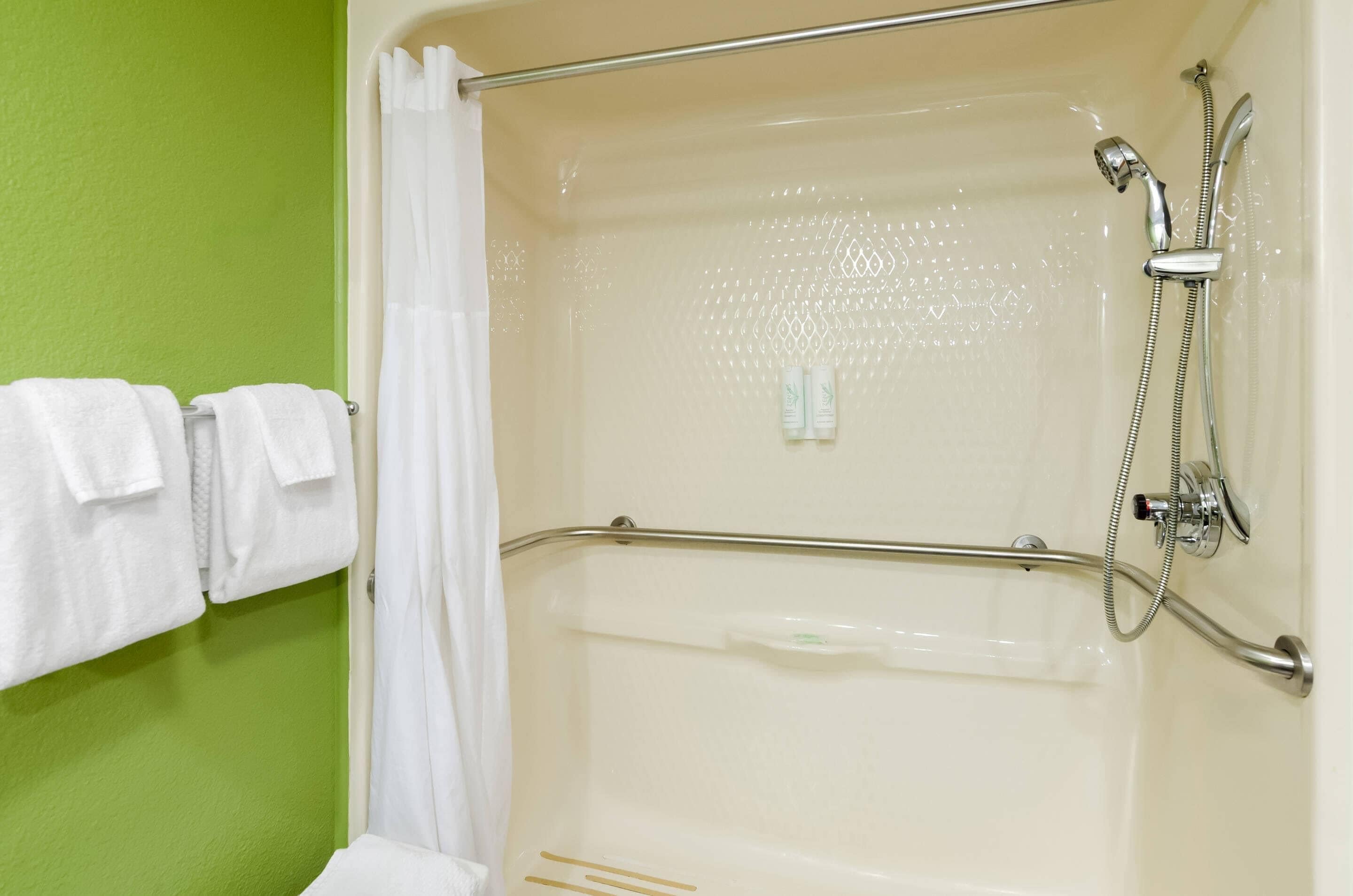 A shower area with a glass door, a showerhead, and a handheld shower attachment.