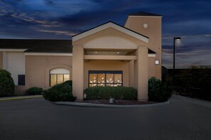 A modern building with a beige facade, a central entrance with glass doors, and a small parking area. - Sleep Inn Beaver - Beckley (Beaver)