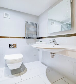 A modern bathroom with a white toilet, a sink with a mirror above it, and a towel rack.