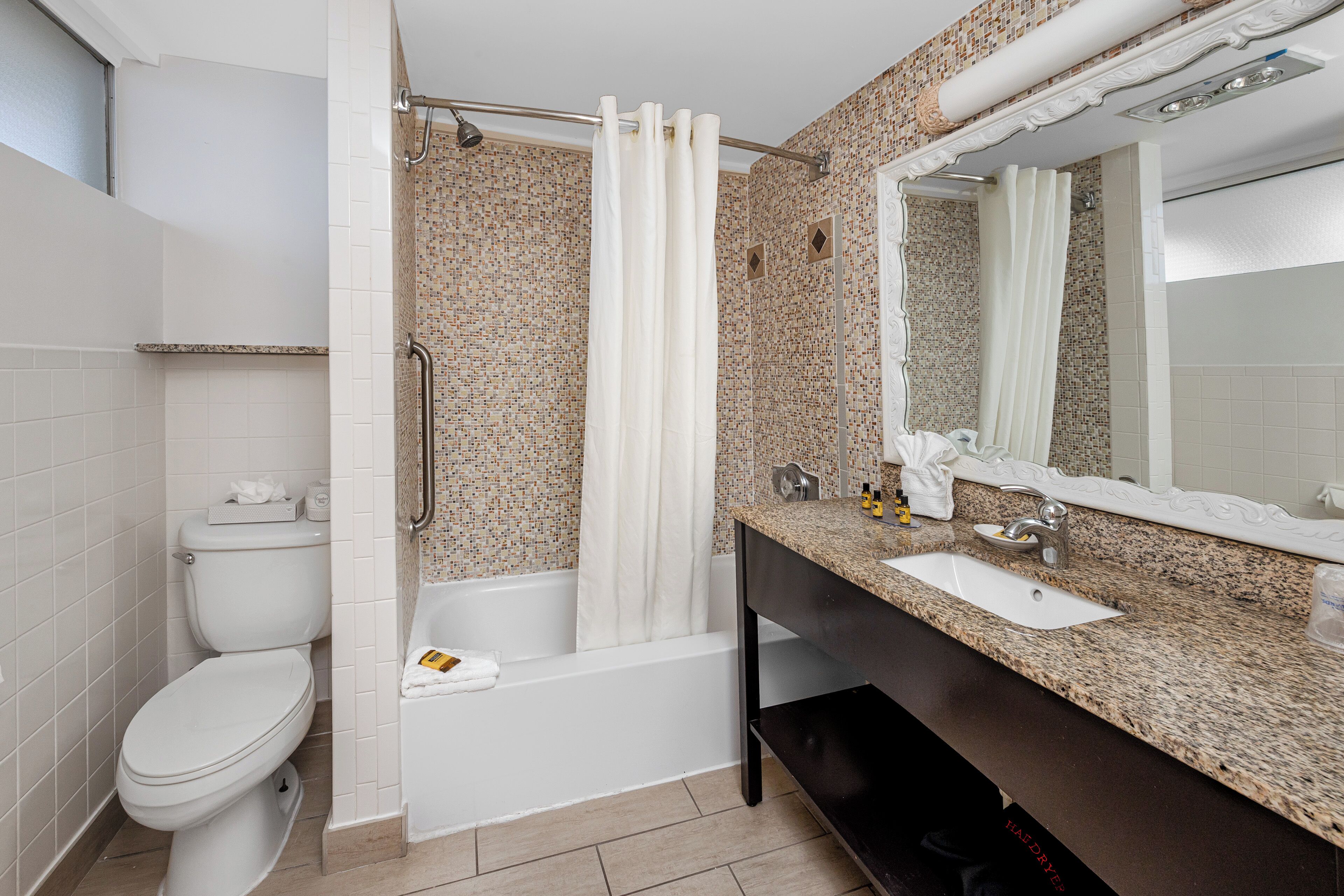 Un baño con inodoro, bañera y lavamanos.