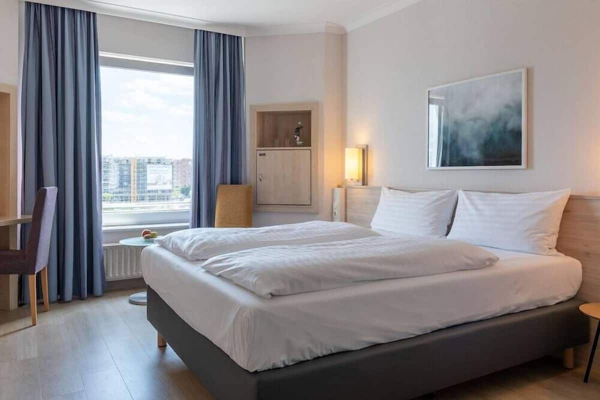 Ropa de cama hipoalergénica y caja de seguridad en la habitación