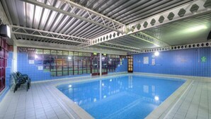 An indoor swimming pool with clear blue water, tiled walls, and a metal roof structure. - Cobden Hotel Birmingham (Birmingham)