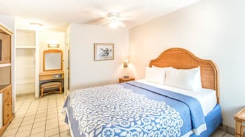 Un dormitorio con cama, mesita de noche y ventilador de techo.