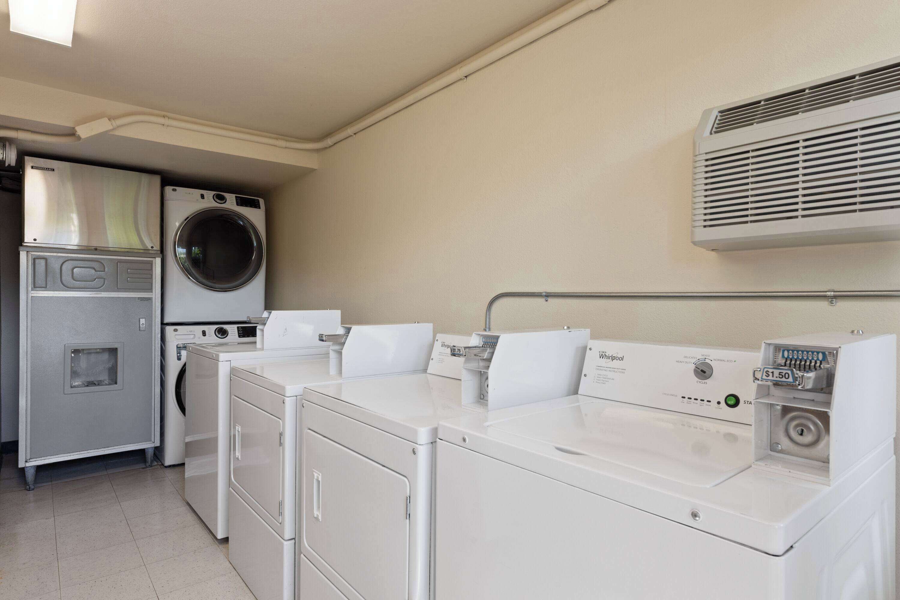 A laundry room with a front-loading washer, a top-loading dryer, and a utility cabinet labeled "ICE".