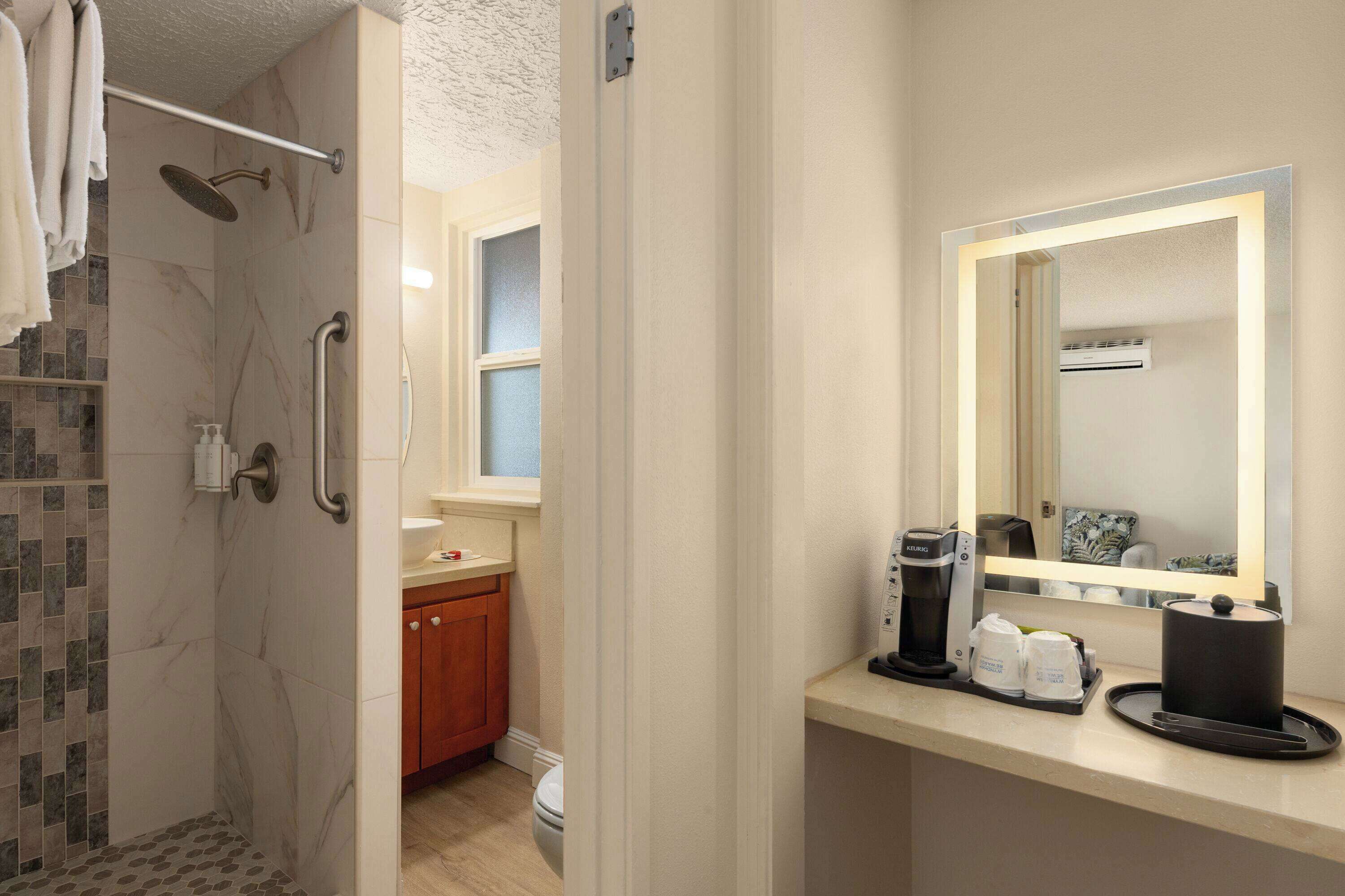 A hotel bathroom with a shower, toilet, and sink.