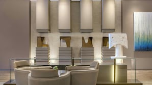 A modern reception area with a glass desk, leather chairs, and a minimalist wall design.