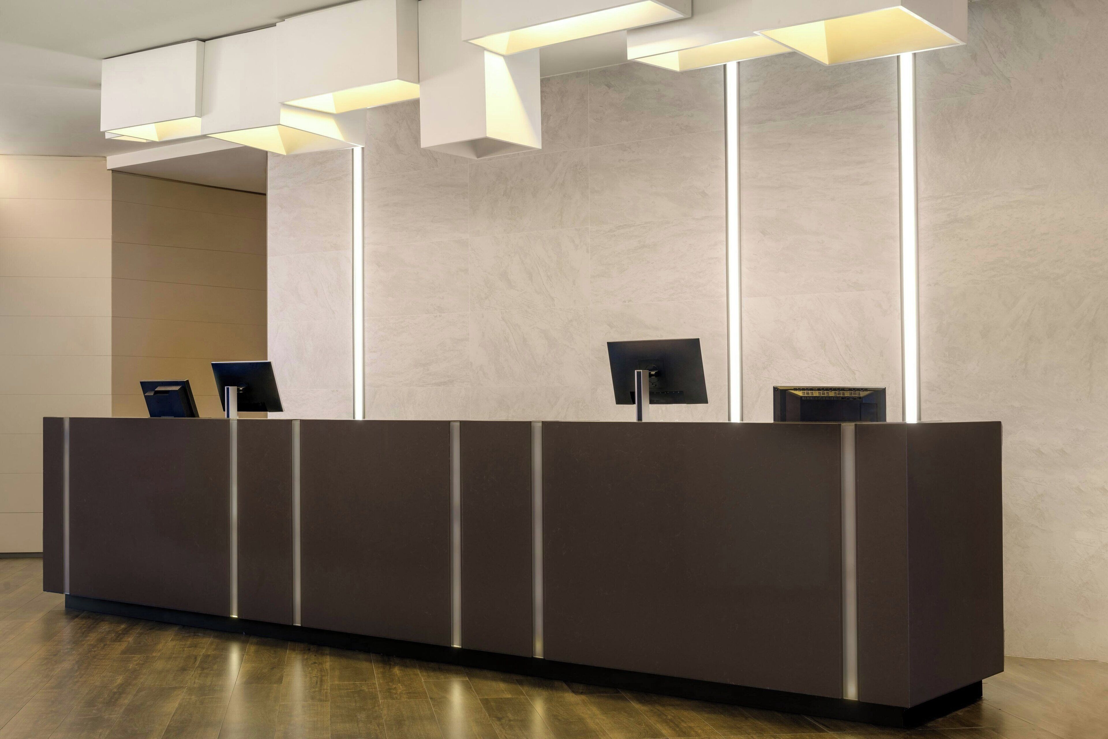Una moderna recepción con iluminación integrada, un televisor de pantalla plana y una pantalla digital.