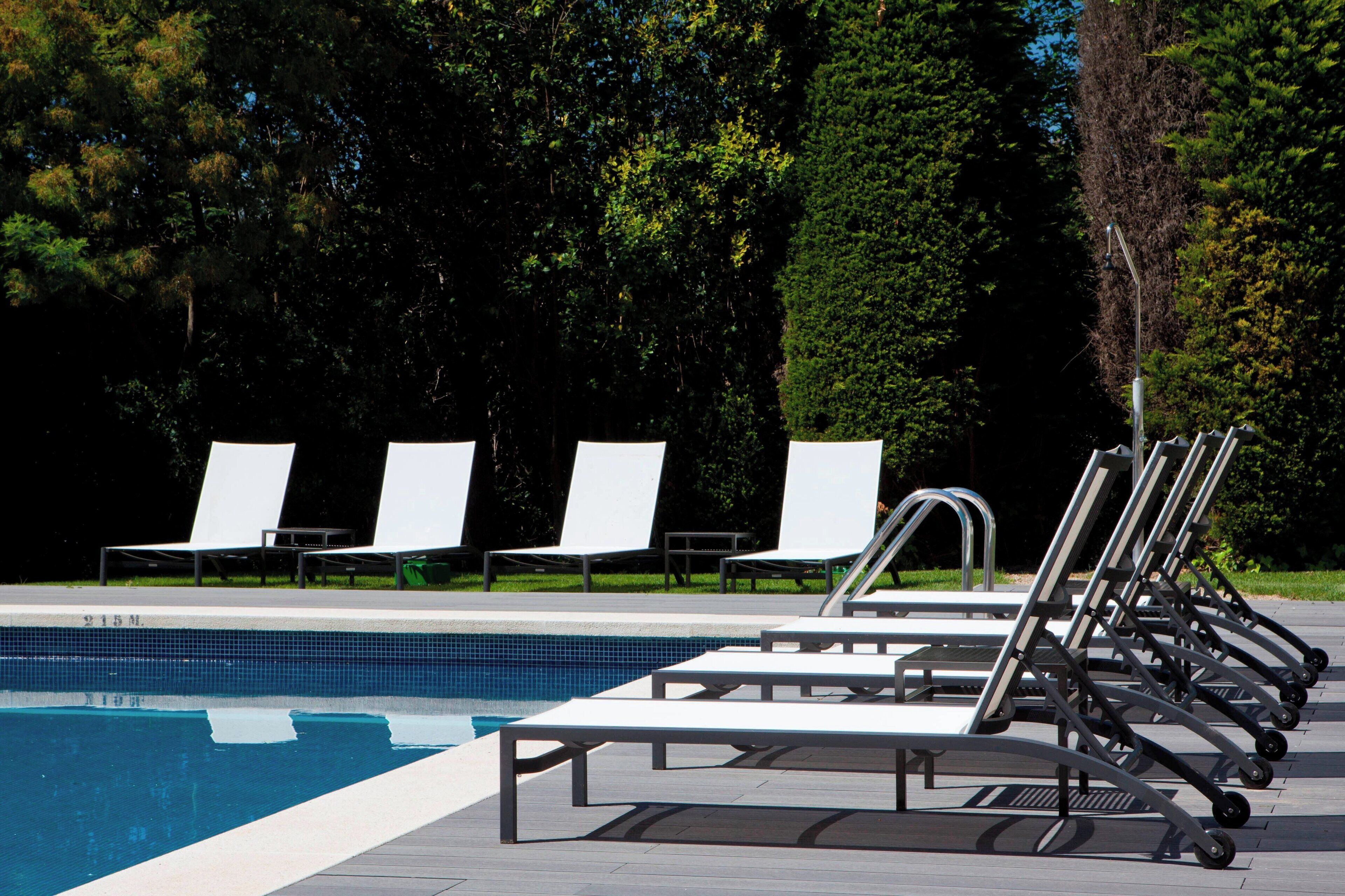 A swimming pool with lounge chairs and a metal structure.