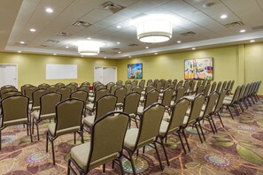 A conference room with rows of chairs, a whiteboard, and two paintings on the walls. - Holiday Inn Express Wilkesboro by IHG (North Wilkesboro)