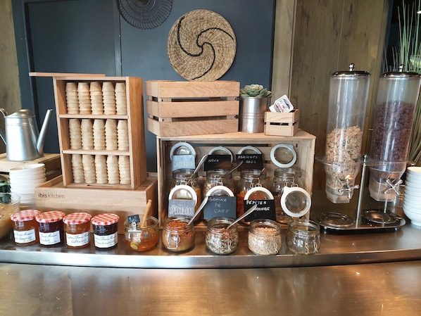 A variety of food items and condiments displayed on a counter, including jars labeled with names like "CASSONADE" and "ABRICOTS SECS".