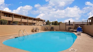 A swimming pool with lounge chairs and a building in the background. - Knights Inn Page (Page)