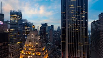 Un paisaje urbano con una mezcla de edificios históricos y modernos, incluyendo una imponente torre de reloj y un rascacielos.