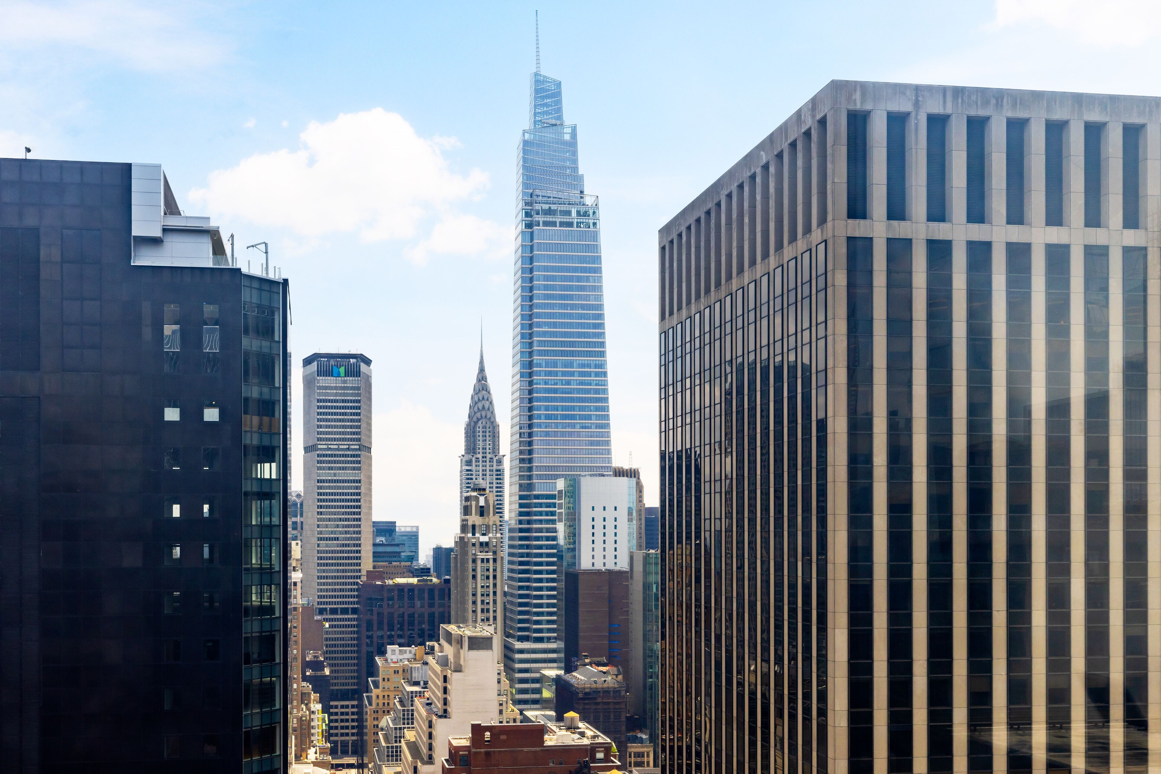 A cityscape with modern skyscrapers, including a prominent tower with a unique design.
