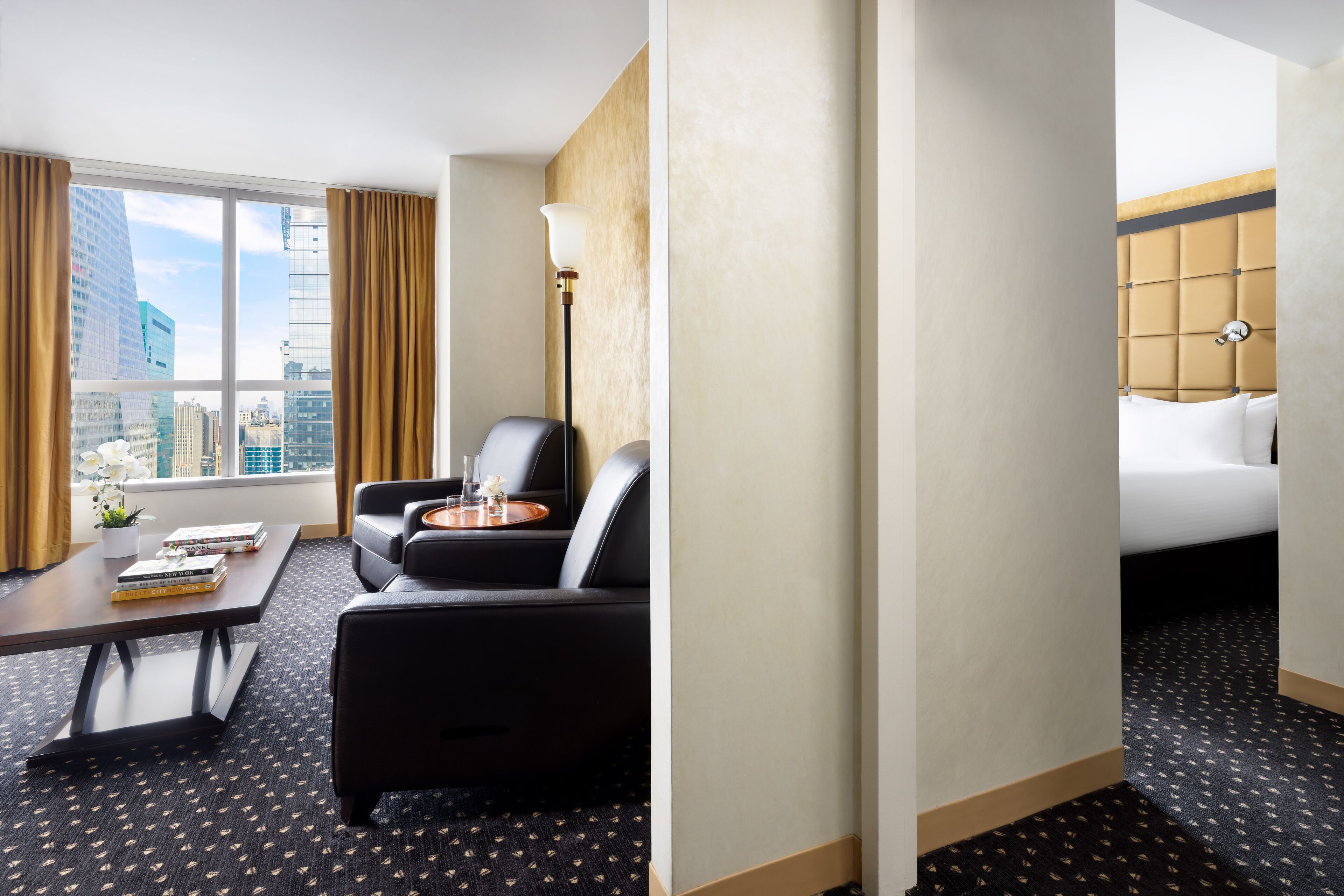 Una habitación de hotel con vista a la ciudad, un sofá, una mesa de centro y una cama.