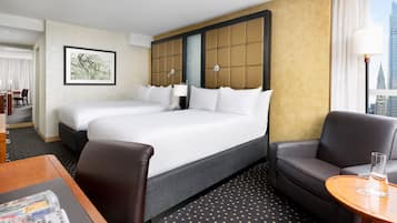 Une chambre d’hôtel avec un grand lit, un canapé, un bureau et une vue sur la ville.