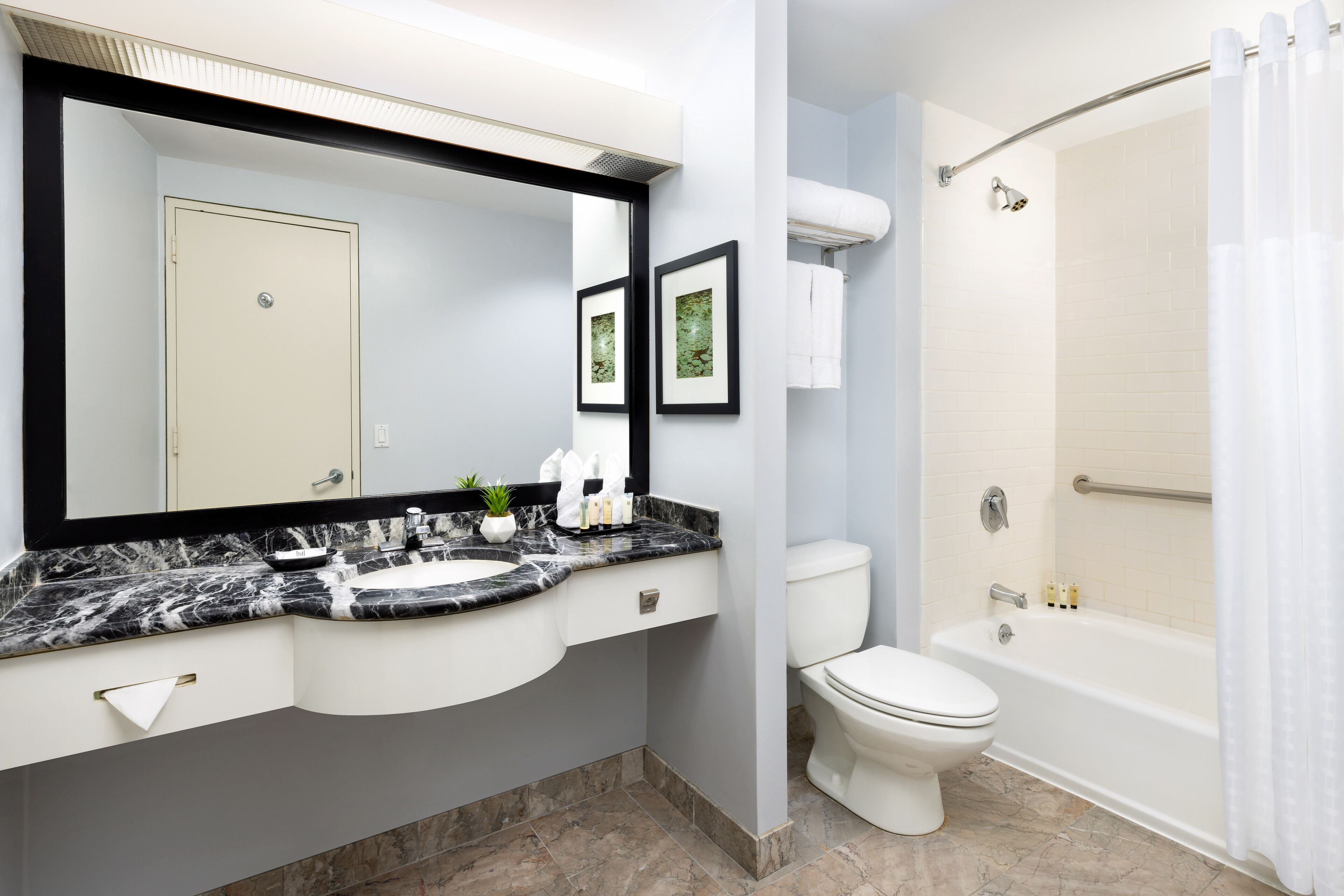 Un baño con lavamanos de mármol, inodoro y bañera.