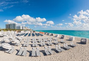 On the beach, white sand, beach cabanas, sun loungers