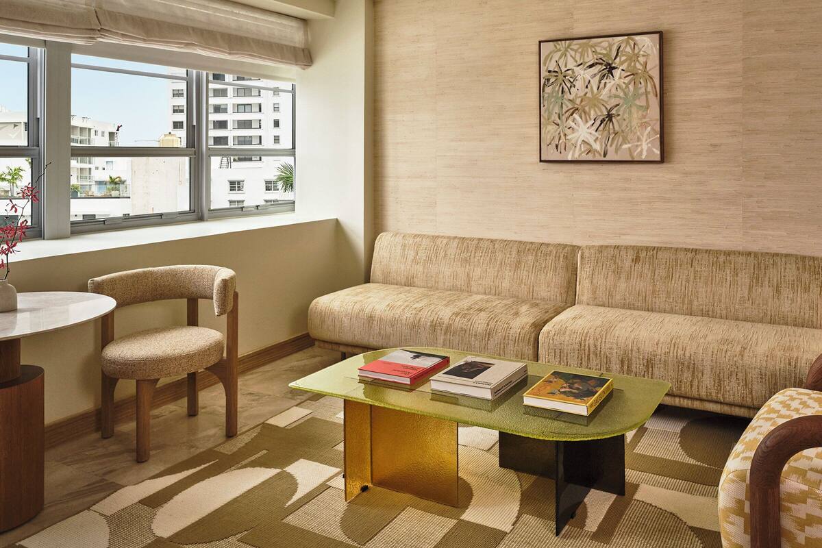 A living room with a sofa, a round table, and a coffee table with books.