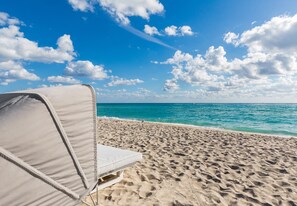 On the beach, white sand, beach cabanas, sun loungers