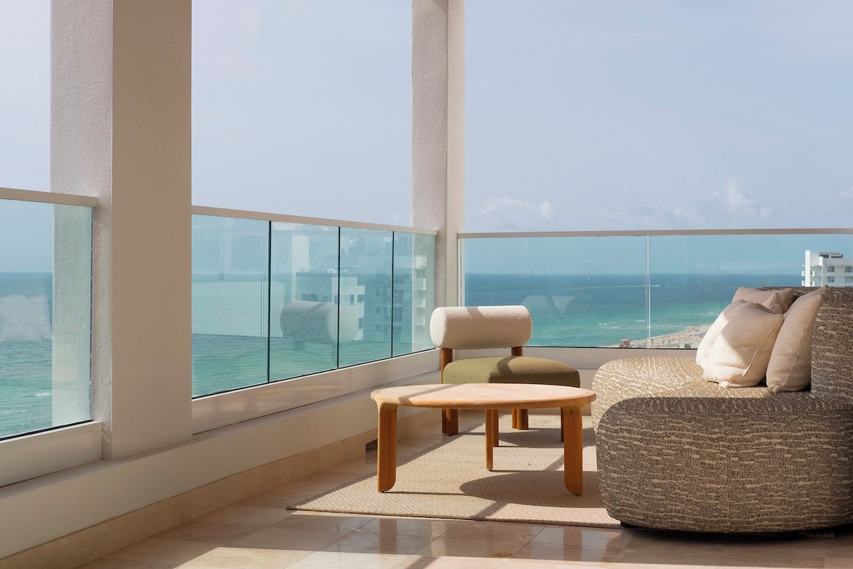 A spacious balcony with a view of the ocean and a cityscape.