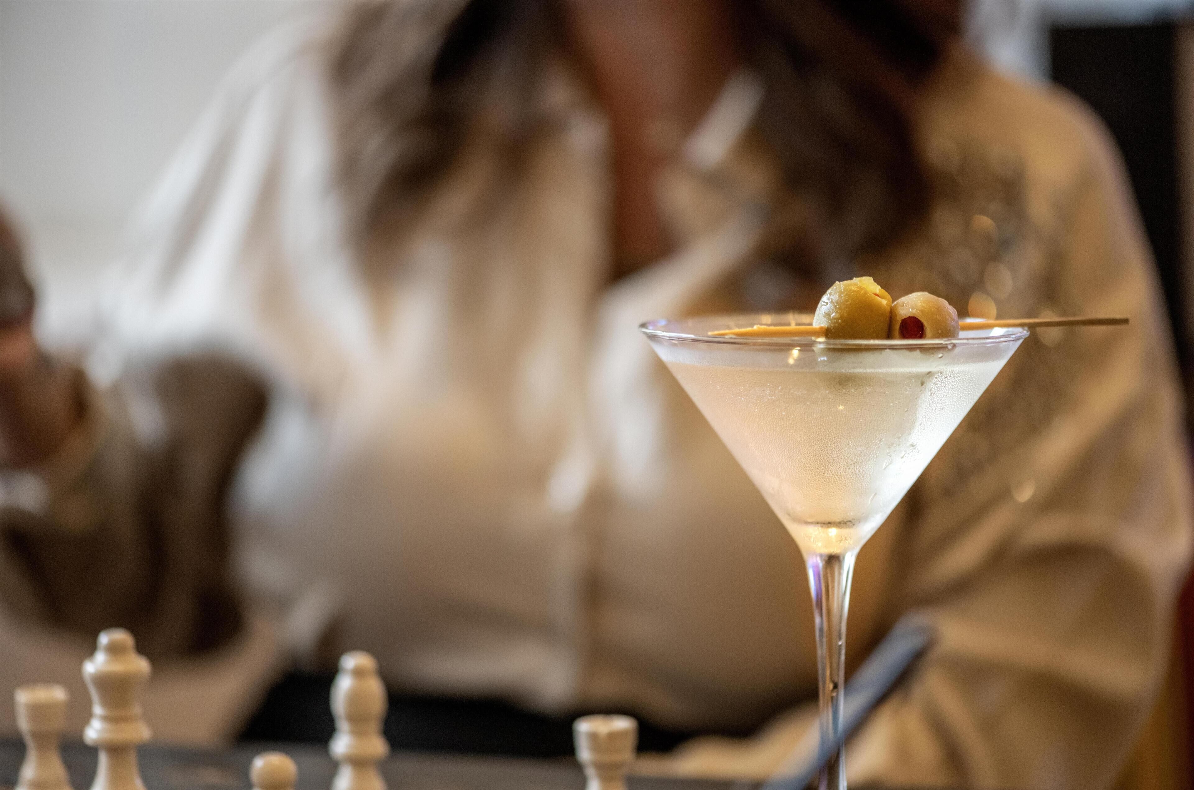 Una copa de martini con una guarnición sobre una mesa.