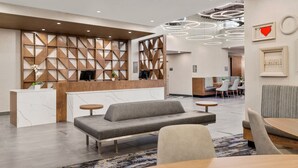 Un vestíbul modern amb una recepció, zona de seients i espai de dinar.
