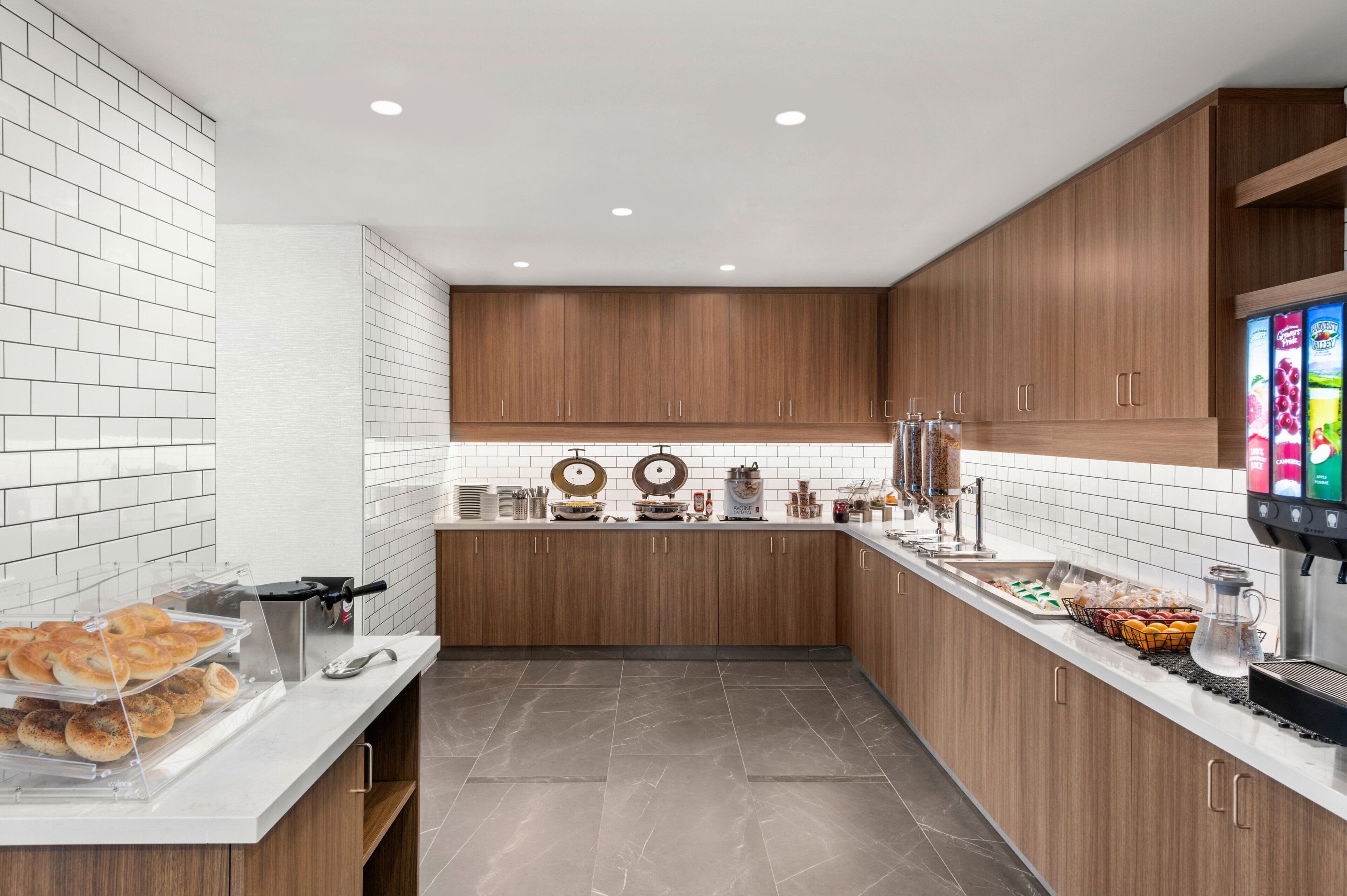Una cocina moderna con armarios de madera, encimera blanca y una cafetera.
