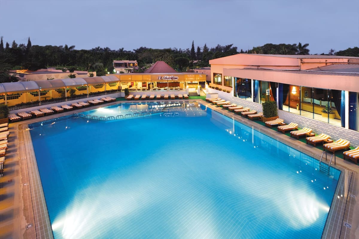 A large indoor swimming pool with lounge chairs and a restaurant named "Il Giardino" in the background.