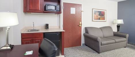 A compact living space with a kitchenette, a dining area, and a seating area.