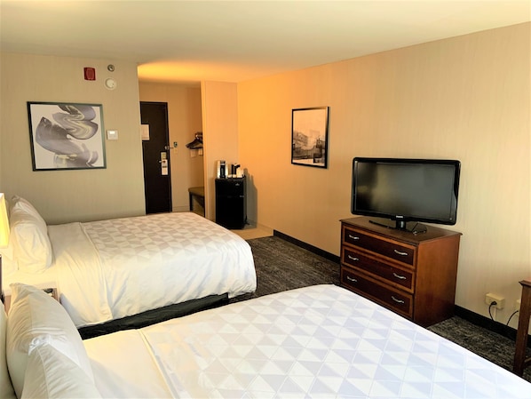 A hotel room with two beds, a television, a dresser, and a coffee machine. - Holiday Inn & Suites Chicago-Carol Stream (Wheaton) by IHG (Carol Stream)