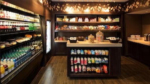 A well-stocked beverage refrigerator, a variety of snack foods, and a selection of packaged goods.
