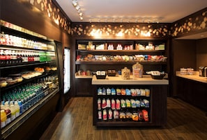 A well-stocked convenience store with shelves of snacks, beverages, and household items.