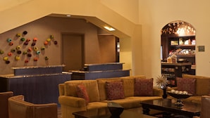 A lobby with a reception desk, a sofa, a coffee table, and a bookshelf.