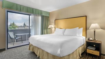 A hotel room with a bed, two bedside lamps, a nightstand, a chair, and a view of the outdoors through a sliding door.