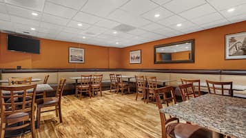 Um restaurante com cabines, mesas e cadeiras.